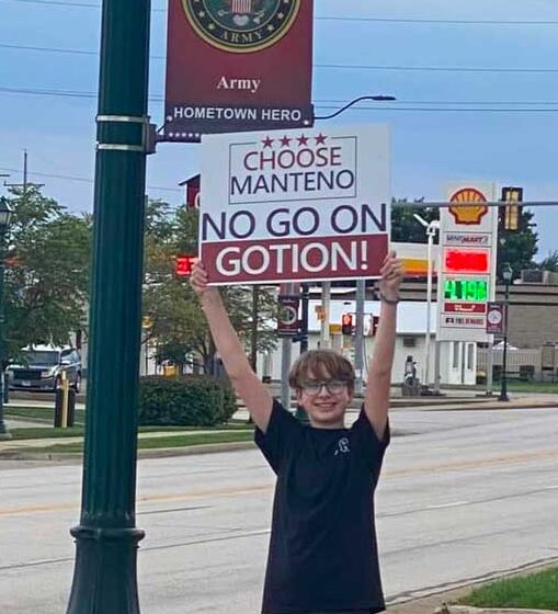 young man holding sign in Manteno
